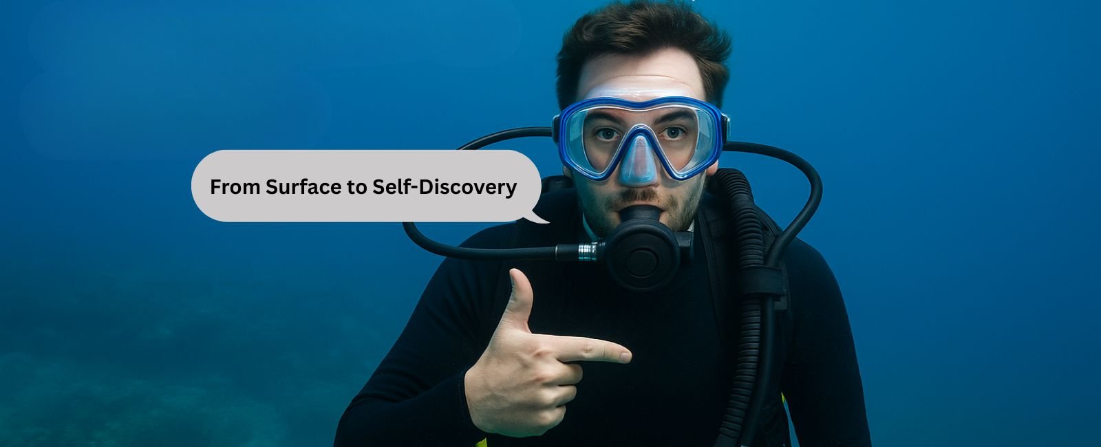 A scuba diver pointing toward their chest underwater in Dubai, representing the self-discovery journey taught in Nemo’s diving courses.